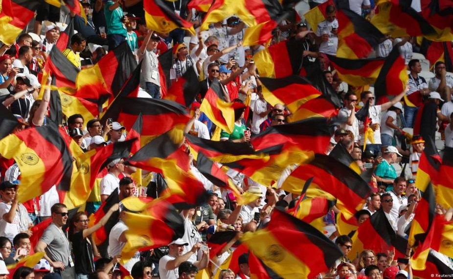 футбольные болельщики с флагами России и Германии на стадионе